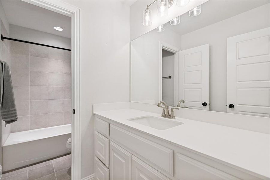 White vanity with shaker-style cabinetry, an integrated sink, and brushed nickel faucet