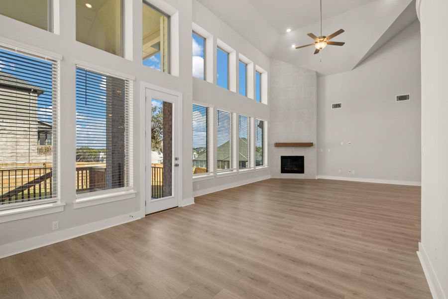 Soaring ceiling, floor to ceiling fireplace, and abundant windows in Open Concept Family Room