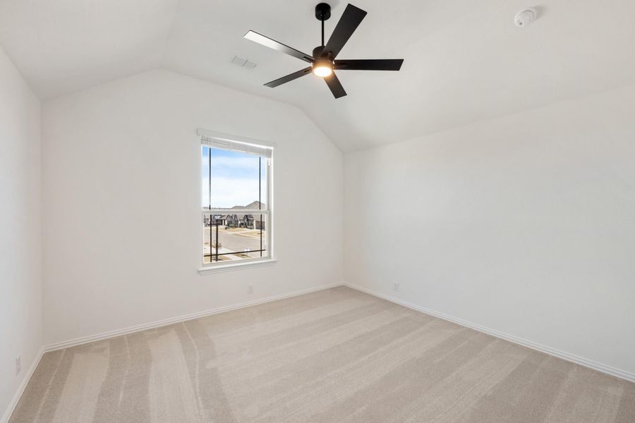 Empty bedroom with vaulted ceiling, black ceiling fan, carpet flooring, and single window