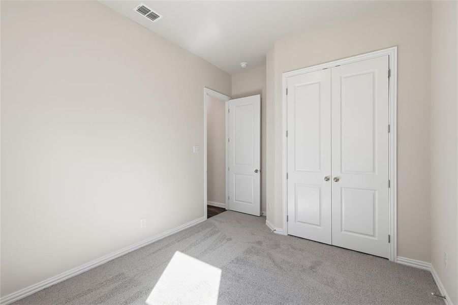Neutral-toned walls complement plush grey carpeting