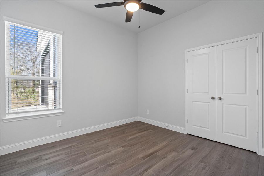 This inviting secondary bedroom combines comfort and modern elegance, featuring tile flooring, high ceilings with ceiling fan, neutral color palette, and abundant natural light streaming through a large window with privacy blinds. This inviting secondary bedroom combines comfort and modern elegance, featuring tile flooring, high ceilings with ceiling fan, neutral color palette, and abundant natural light streaming through a large window with privacy blinds.