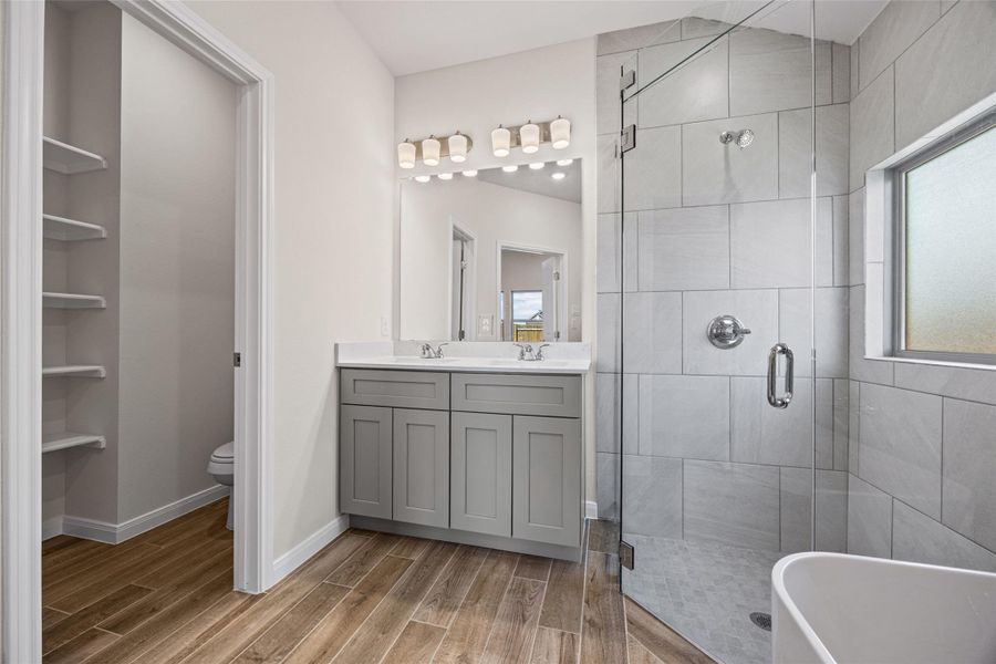 An elegant bathroom features a tiled walk-in shower and wood-look tile flooring. An elegant bathroom features a tiled walk-in shower and wood-look tile flooring.