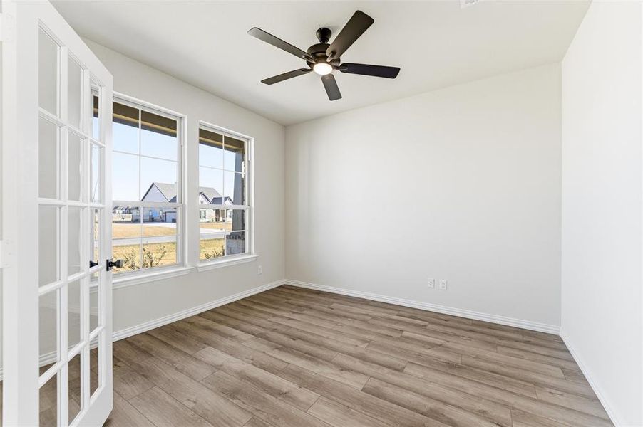 Empty room with light wood-style floors and ceiling fan