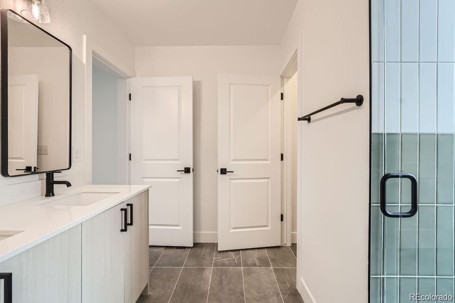 Primary bathroom with spacious shower, private water closet, and extra storage closet.