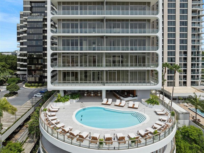 Elevated resort-style swimming pool with panoramic views, luxury loungers, and private relaxation spaces overlooking Coconut Grove.
