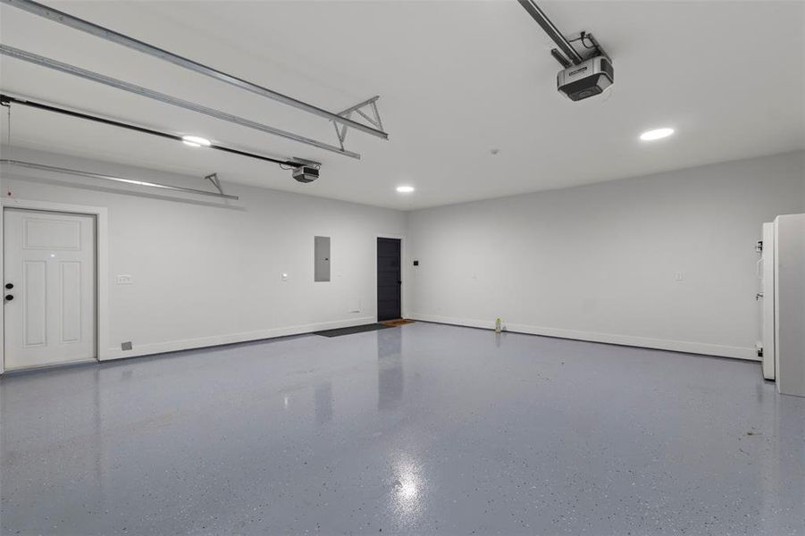 Oversized fully insulated 26x26 garage featuring 10x8 garage doors with very quiet linear operators, sleek finished floors, abundant lighting, and an EF-5 rated tornado pod—offering secure, functional space with added peace of mind.