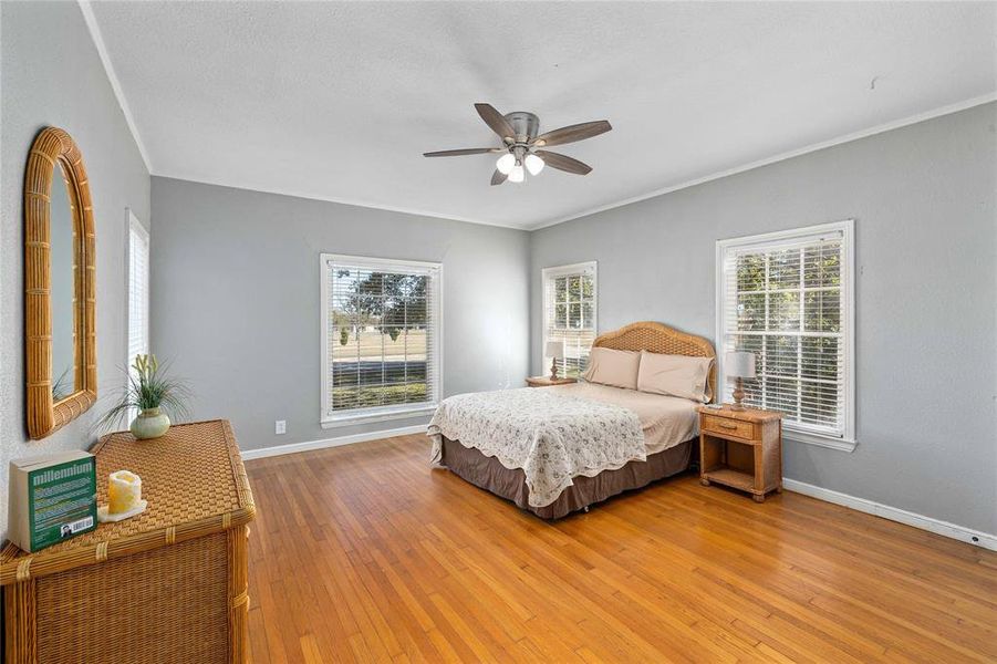Large bedroom with hardwood floors and built in book shelves