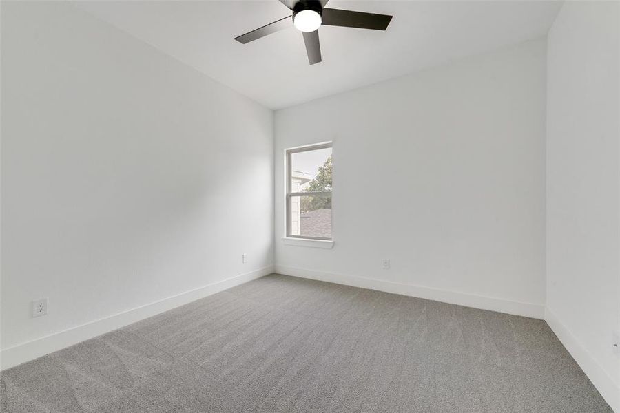 Spare room with light colored carpet and a ceiling fan Spare room with light colored carpet and a ceiling fan