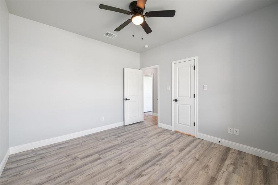 Unfurnished bedroom with light wood-style floors and ceiling fan Unfurnished bedroom with light wood-style floors and ceiling fan
