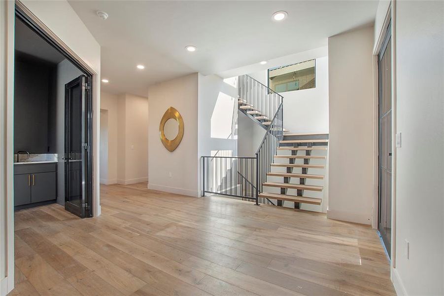 Unfurnished living room with light hardwood / wood-style flooring and sink