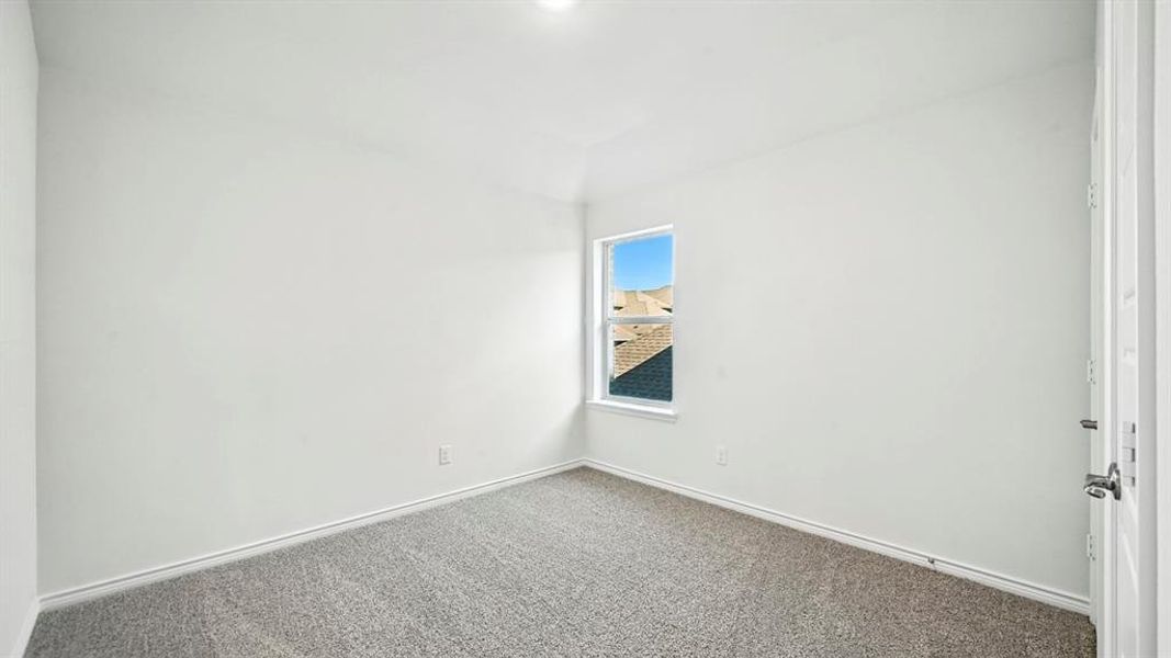 Spare room featuring baseboards and carpet floors