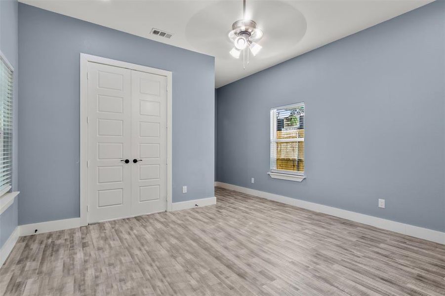 Unfurnished bedroom featuring a closet, light wood-type flooring, and ceiling fan