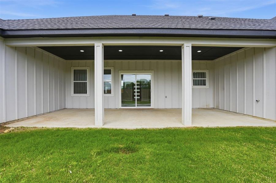 Covered concrete patio featuring recessed lighting and a sliding glass door