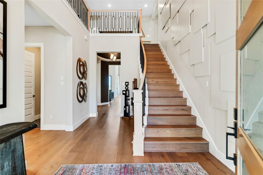 Stairs featuring wood finished floors and a high ceiling Stairs featuring wood finished floors and a high ceiling