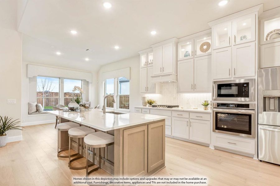 Kitchen with large center island, white cabinets, stainless steel appliances, and light hardwood floors