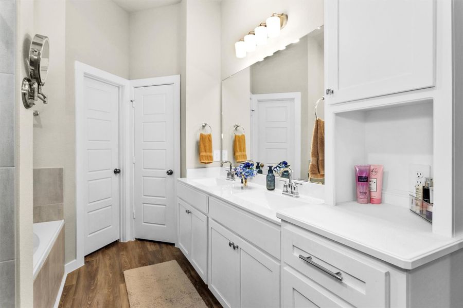 Welcome to your Primary En Suite. Featuring double sinks, soaking tub, stand up shower and enclosed water closet. Notice the tall cabinet on the right. This was added by the Seller's for extra storage making this bathroom feel all the grander. Not picture is additional cabinet built in enclosed water closet above toilet that was also installed by them. Welcome to your Primary En Suite. Featuring double sinks, soaking tub, stand up shower and enclosed water closet. Notice the tall cabinet on the right. This was added by the Seller's for extra storage making this bathroom feel all the grander. Not picture is additional cabinet built in enclosed water closet above toilet that was also installed by them.