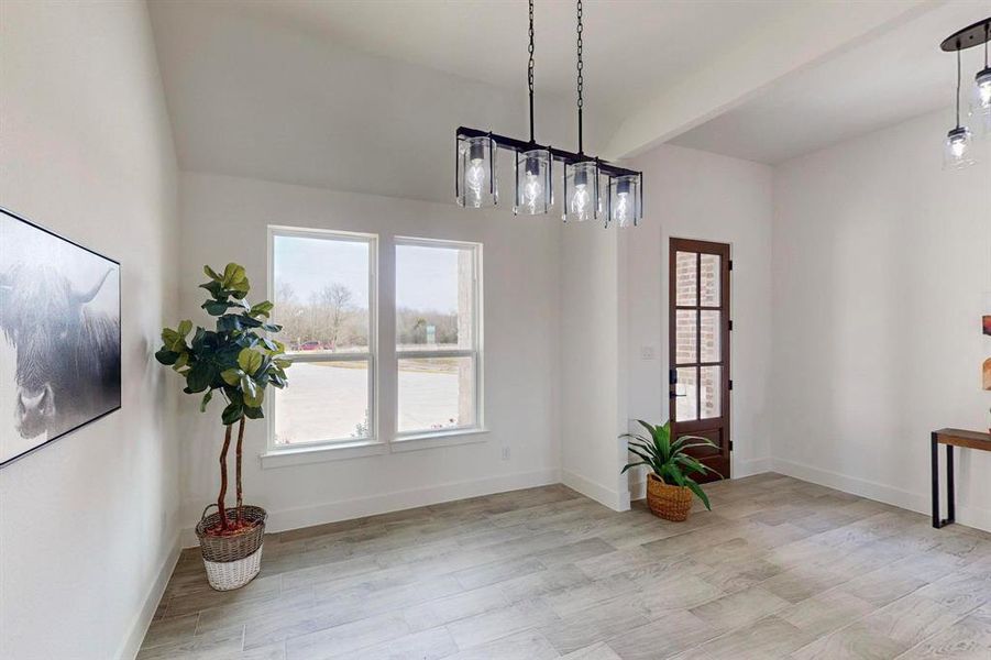 Dining space featuring beamed ceiling and light hardwood / wood-style flooring