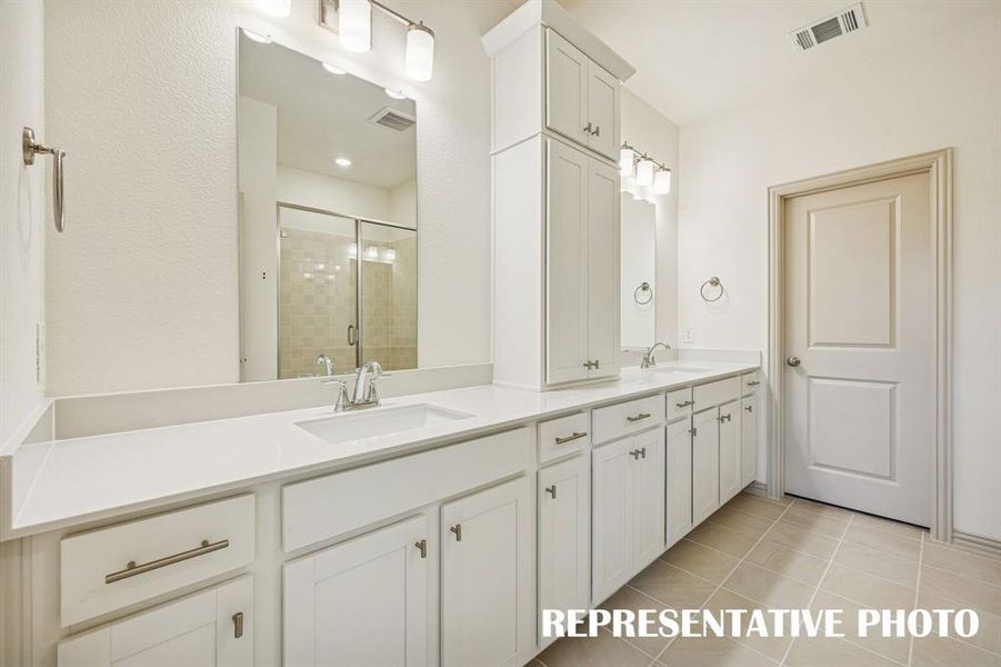 Featuring ample storage and vanity space, this owner's bath was designed with two in mind!  REPRESENTATIVE PHOTO