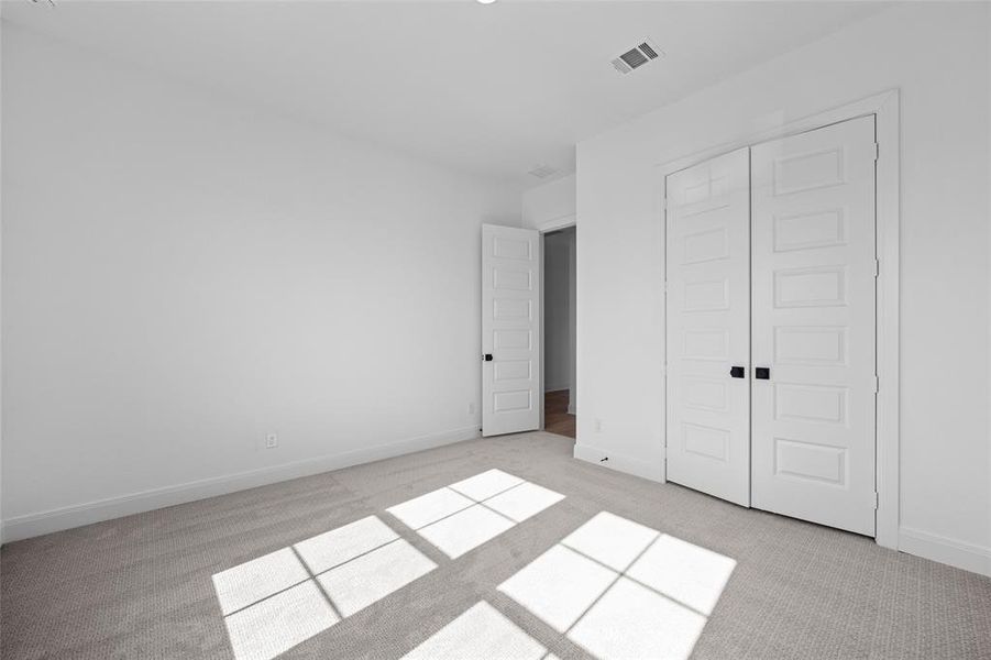 Unfurnished bedroom featuring a closet and light colored carpet