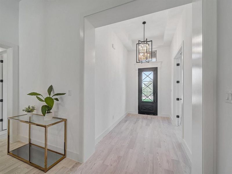 Foyer entrance featuring a chandelier and wood finished floors