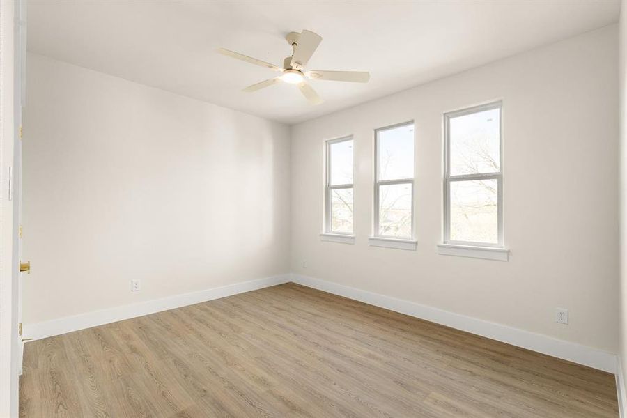 Unfurnished room with light wood-type flooring, ceiling fan, and baseboards