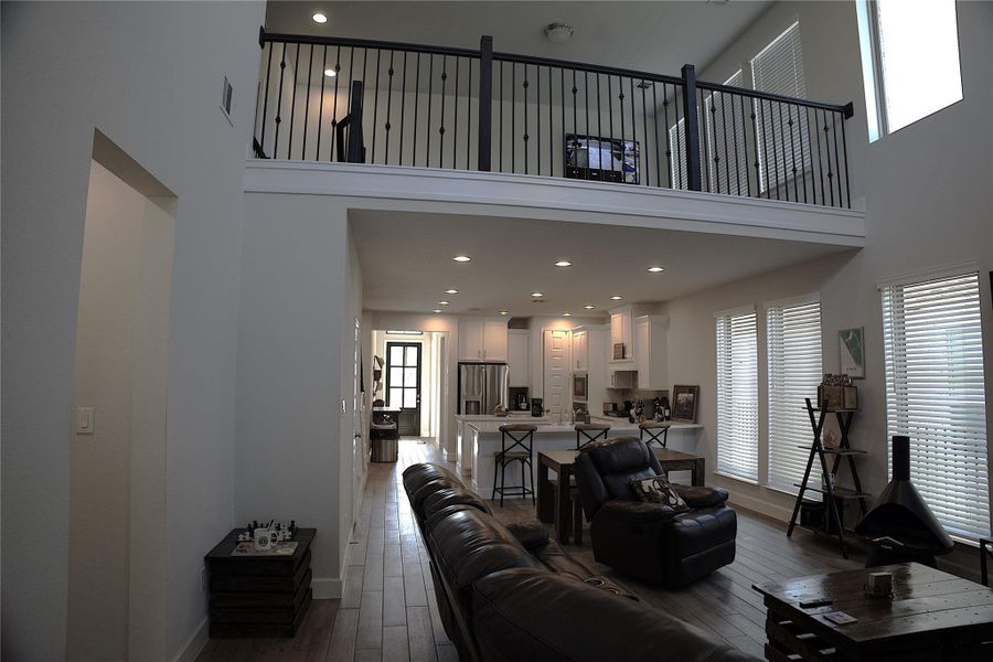 Living room featuring a towering ceiling, dark wood-style flooring, and recessed lighting Living room featuring a towering ceiling, dark wood-style flooring, and recessed lighting