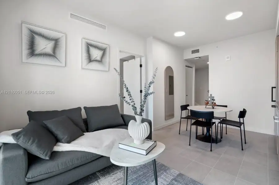 Interior space featuring large-format tile flooring, recessed ceiling lighting, and a neutral color palette