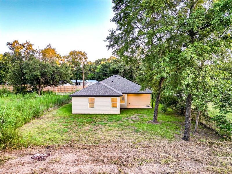 View of home's exterior with roof with shingles and a yard View of home's exterior with roof with shingles and a yard