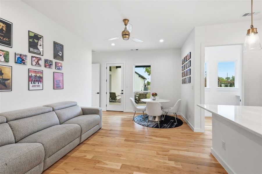 Living room with light wood-type flooring, recessed lighting, and a ceiling fan