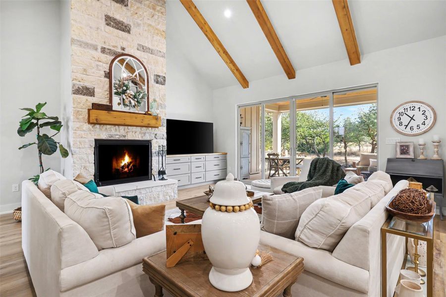 Living area featuring a floor to ceiling stone wood burning fireplace w/ gas, and high vaulted ceiling, custom cabinetry.