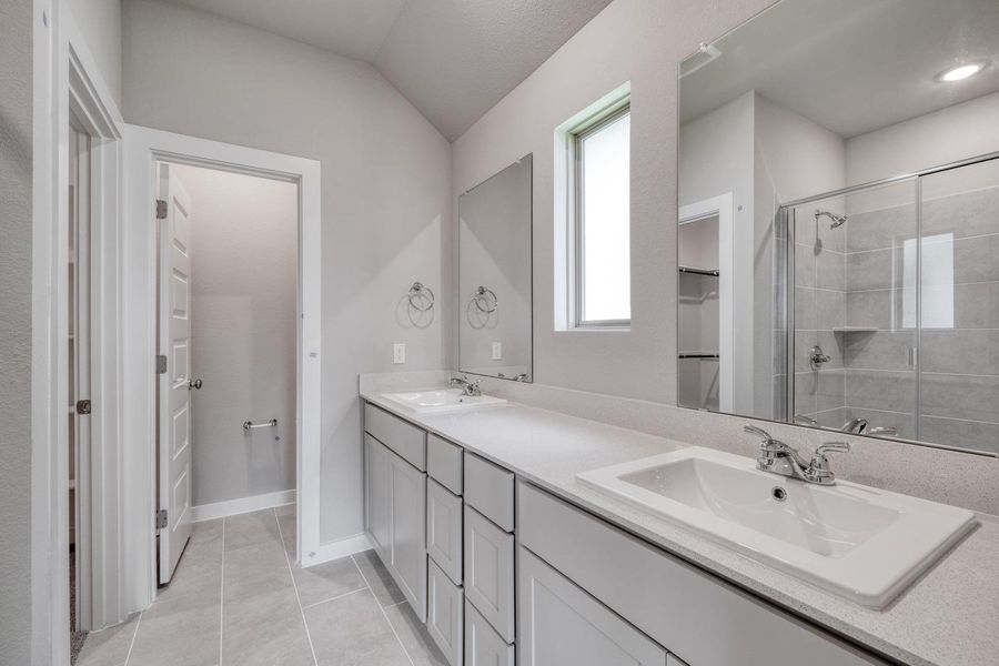 Dual vanities and a spacious shower elevate this primary bathroom's functional design. Dual vanities and a spacious shower elevate this primary bathroom's functional design.
