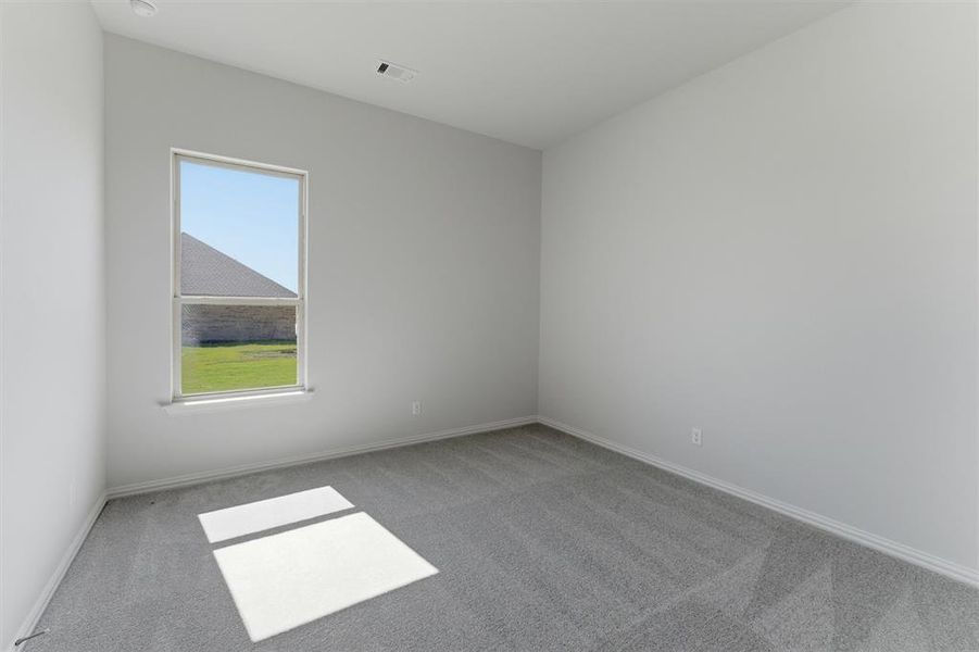 Interior space featuring light gray walls, gray carpeting, and white baseboards