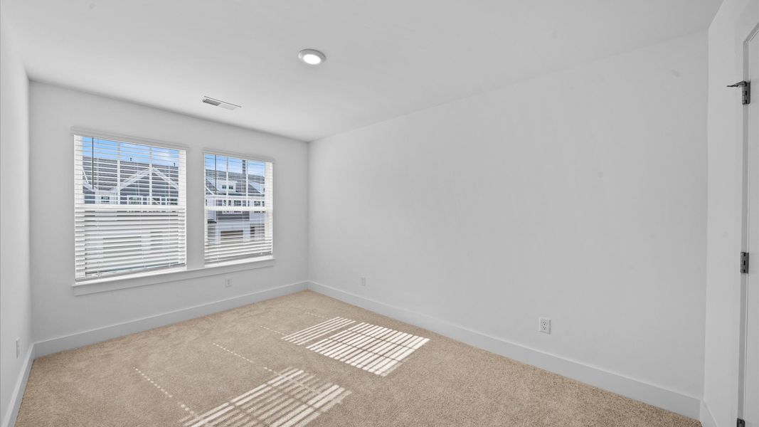 Elegant bedroom retreat featuring soft carpet and oversized windows that create a bright, welcoming space Elegant bedroom retreat featuring soft carpet and oversized windows that create a bright, welcoming space