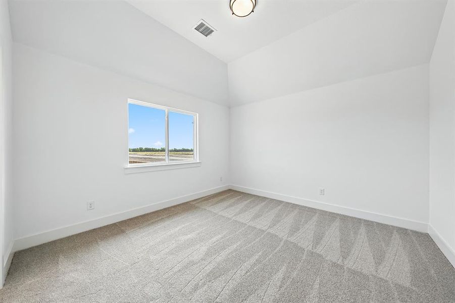 Unfurnished room with light carpet and lofted ceiling