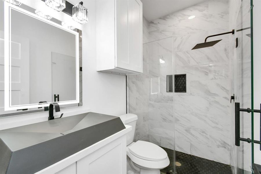 First floor bathroom features a walk in shower and modern vanity.