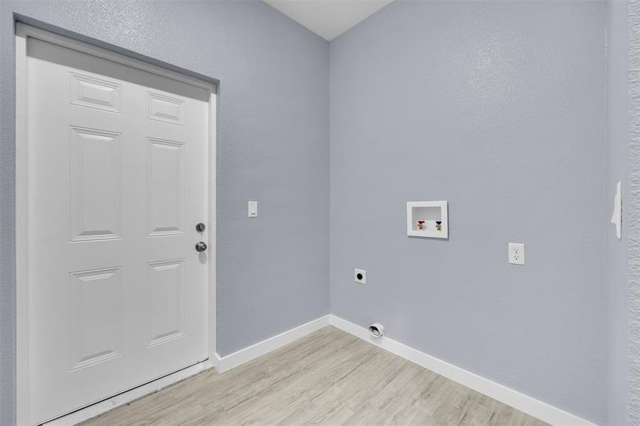 Laundry area with electric dryer hookup, light wood-type flooring, and washer hookup