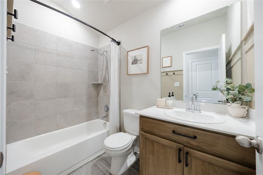 Bathroom with shower / bathtub combination with curtain and vanity