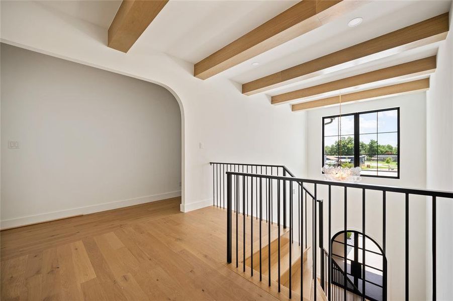 Corridor featuring beam ceiling, wood finished floors, recessed lighting, and arched walkways