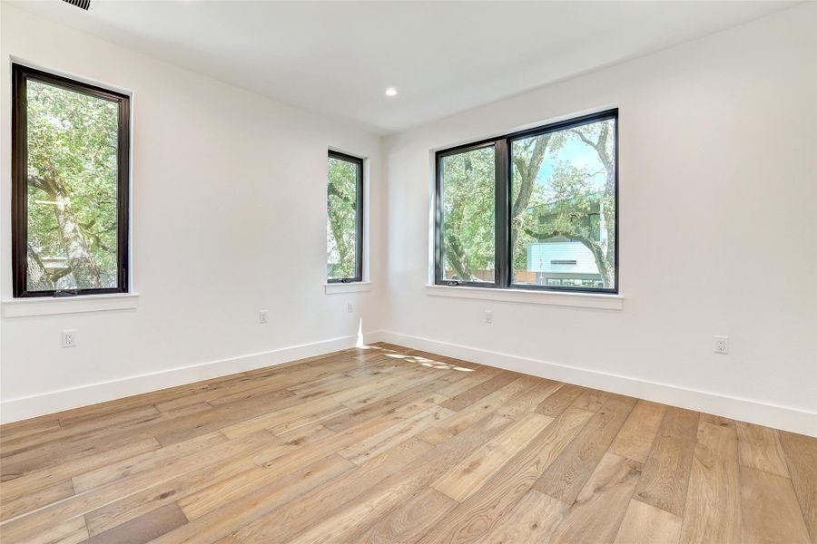Empty room featuring light wood finished floors, baseboards, and recessed lighting