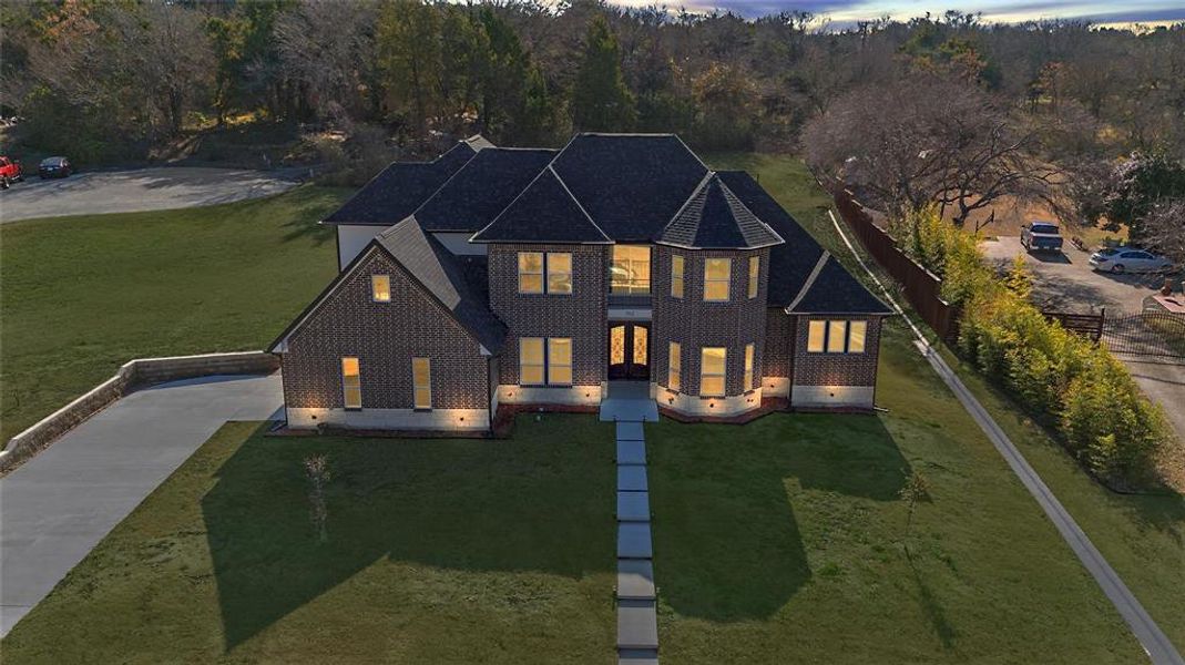 Traditional-style house featuring brick siding, concrete driveway, and a view of trees Traditional-style house featuring brick siding, concrete driveway, and a view of trees