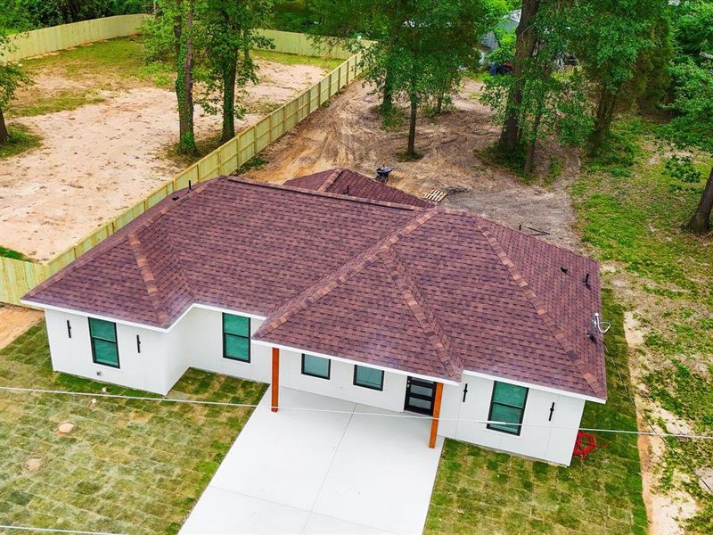 Contemporary single-story residence featuring a brown shingle roof and white exterior Contemporary single-story residence featuring a brown shingle roof and white exterior