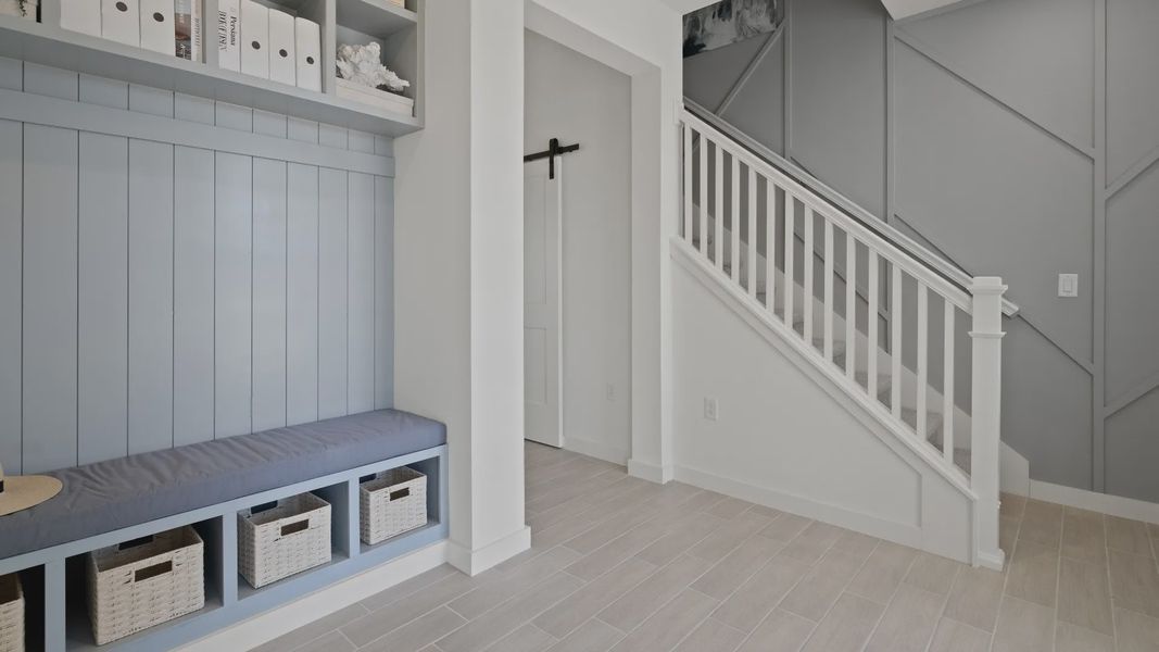 Front entry drop zone and stairs at a DRB Homes Ambersweet model at the Trinity Place community. Front entry drop zone and stairs at a DRB Homes Ambersweet model at the Trinity Place community.