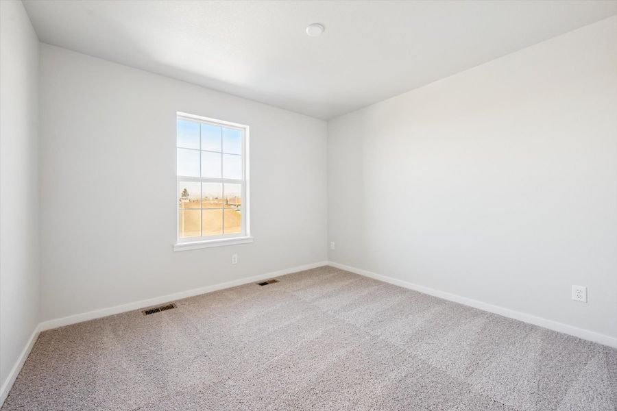 A room with a window and carpet.