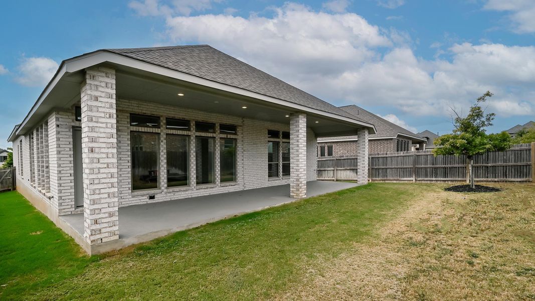 Rear view of house featuring a patio, brick siding, and roof with shingles Rear view of house featuring a patio, brick siding, and roof with shingles