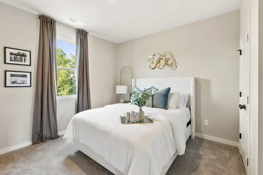 A bedroom with a bed and a mirror.