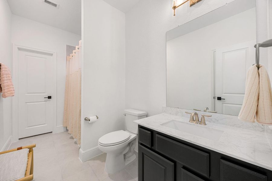 A well-appointed full bath offering a contemporary vanity and clean, neutral finishes.