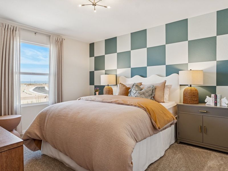 A bedroom with a large window. A bedroom with a large window.