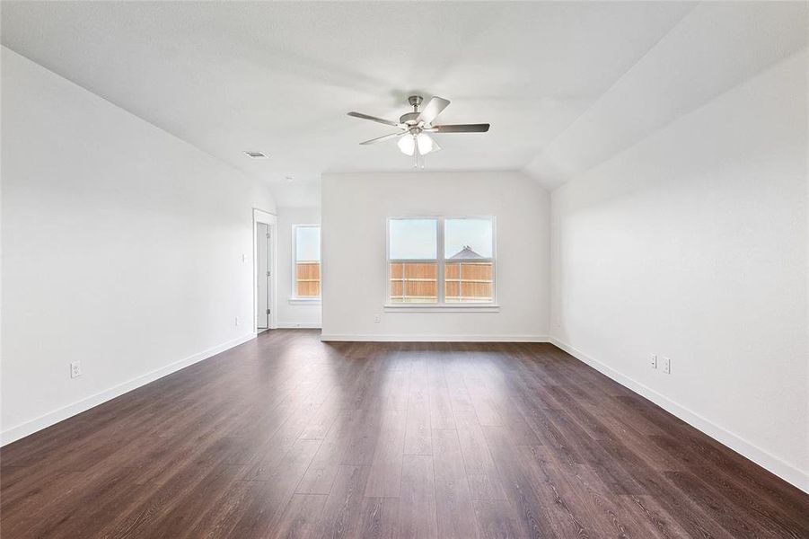 Spare room featuring lofted ceiling, ceiling fan, and dark hardwood / wood-style flooring