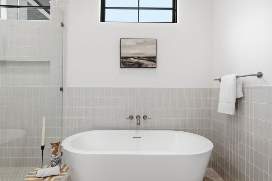 Bathroom with a freestanding bath, tile walls, a wainscoted wall, and tiled shower