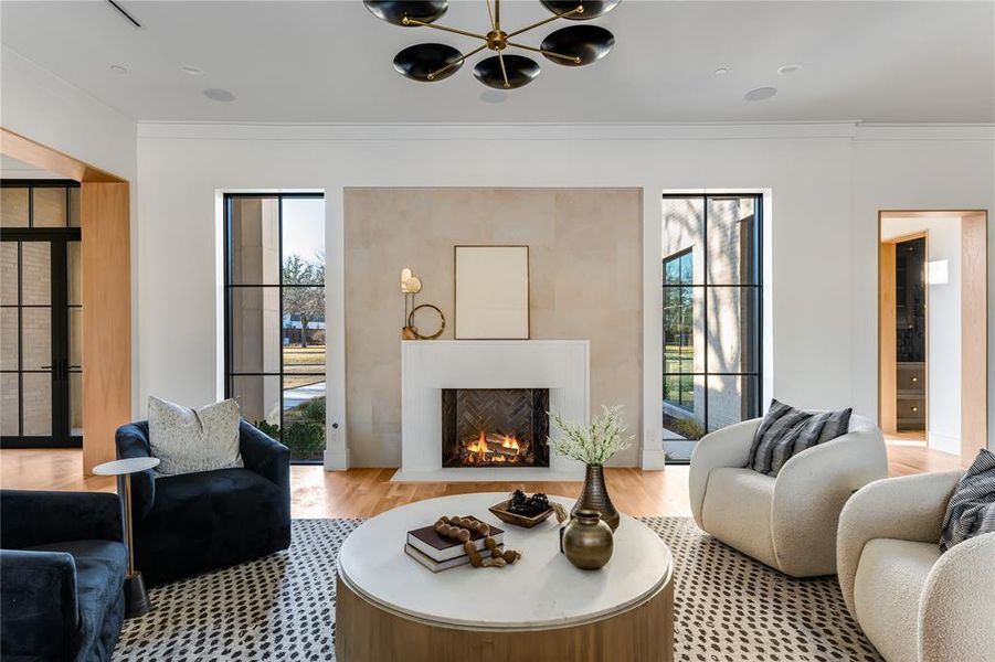 Living room featuring crown molding, a wealth of natural light, and light hardwood / wood-style flooring